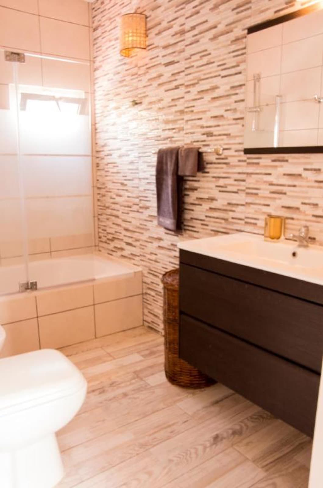 Bathroom with bathtub and natural stone wall